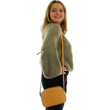 Load image into Gallery viewer, Sac Berthille Minaudière couleur golden, tannage végétal, extérieur en cuir grainé, porté par notre mannequin.
