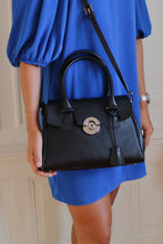 Load image into Gallery viewer, Sac Berthille Mini Cortina noir, tannage végétal, extérieur en cuir grainé plaine fleur, porté par notre mannequin.