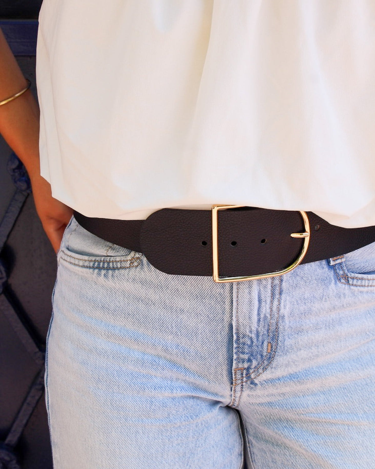 Ceinture Demi-Lune cuir grainé bleu marine portée sur jean, boucle dorée satinée Berthille