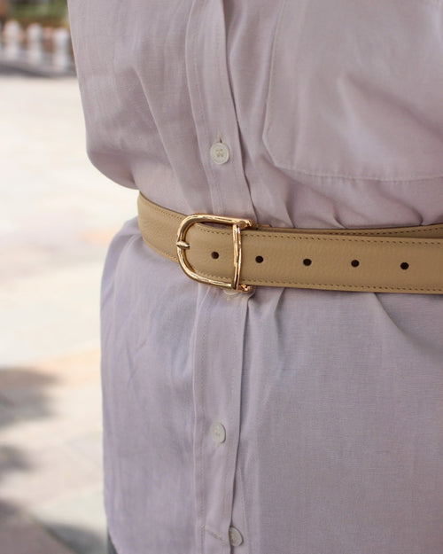Femme portant ceinture bombée cuir beige boucle dorée sur tenue habillée