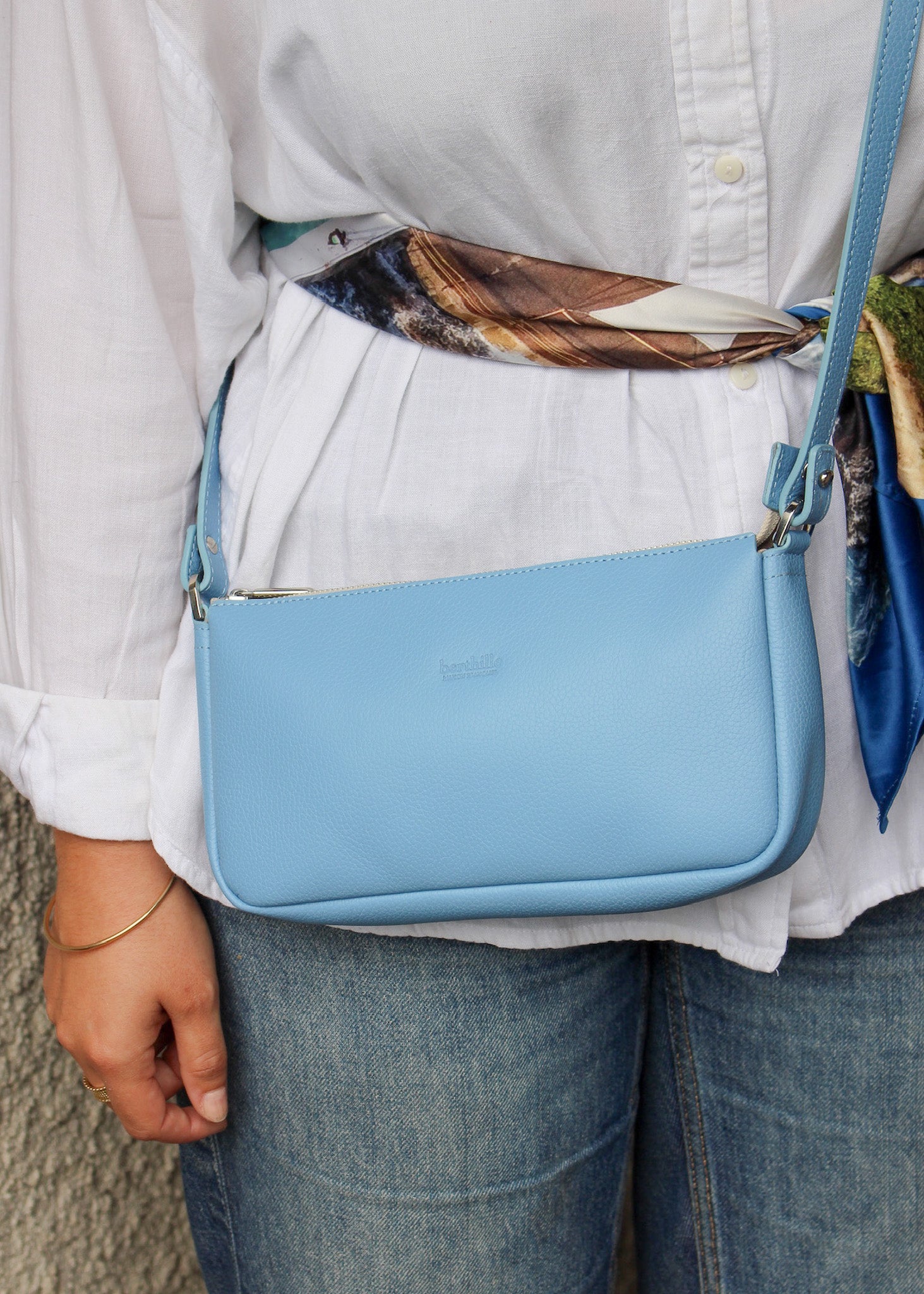 Femme portant sac Berthe cuir bleu ciel en bandoulière travers