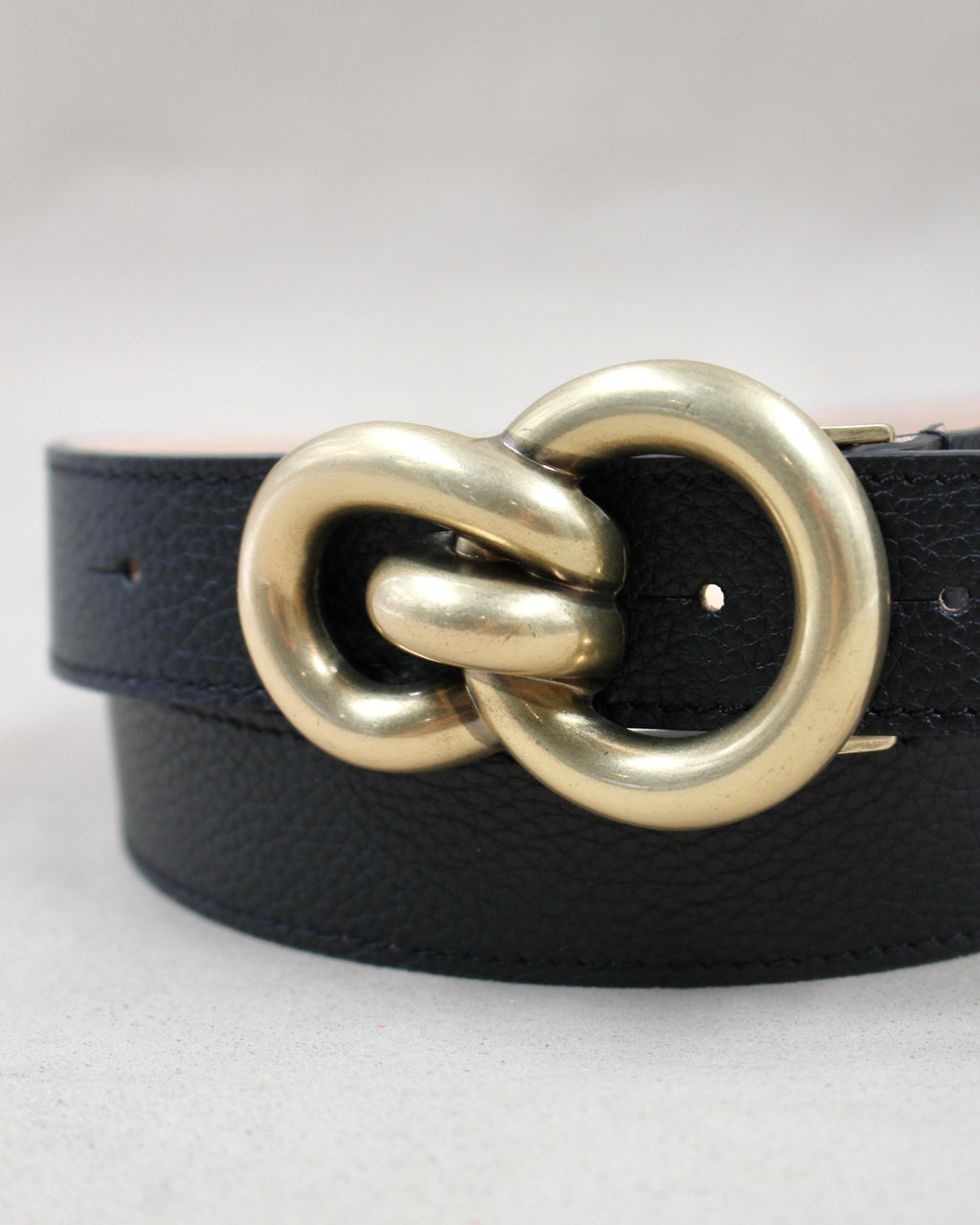 Gros plan boucle double anneaux dorée sur ceinture cuir grainé noir Berthille
