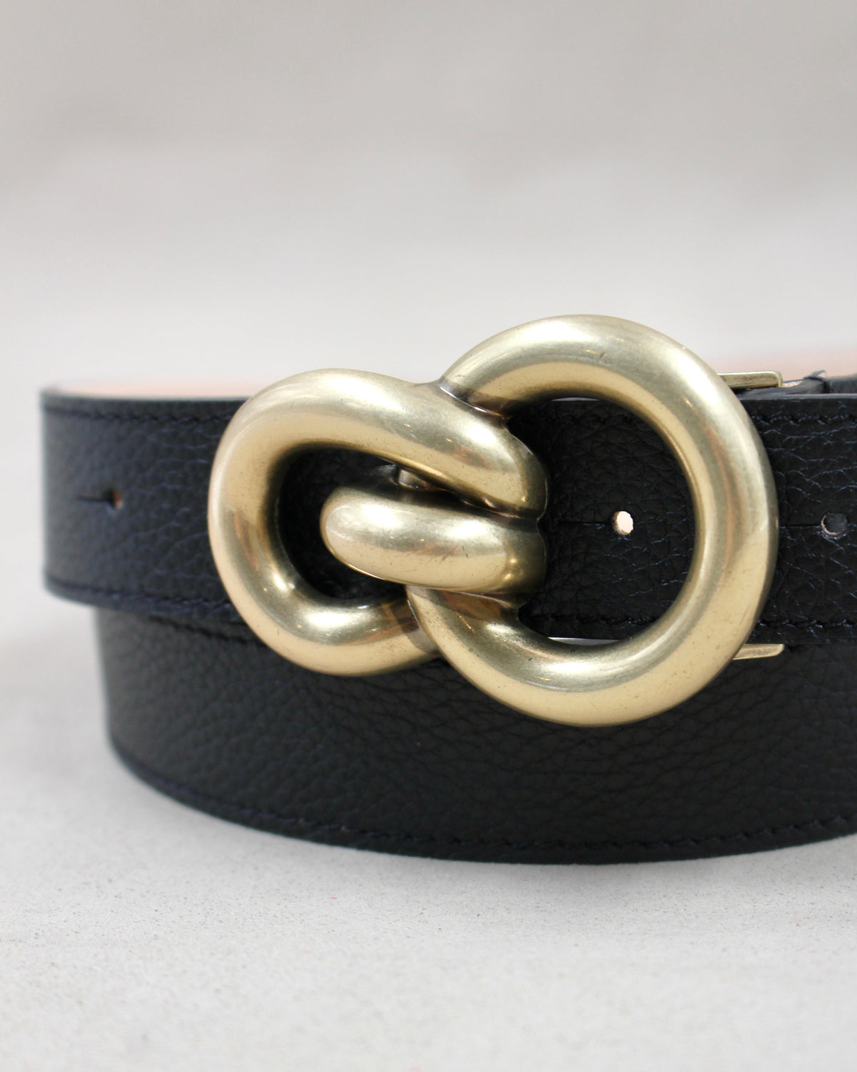 Gros plan boucle double anneaux dorée sur ceinture cuir grainé noir Berthille
