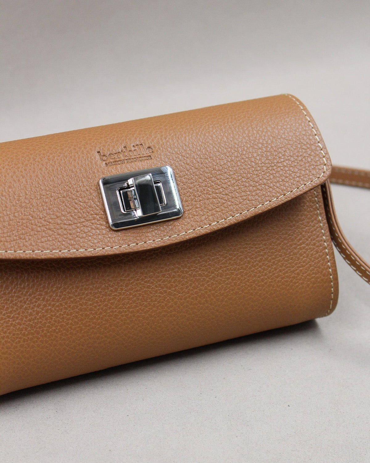 Gros plan fermoir tourniquet argenté sur sac cuir grainé camel Berthille