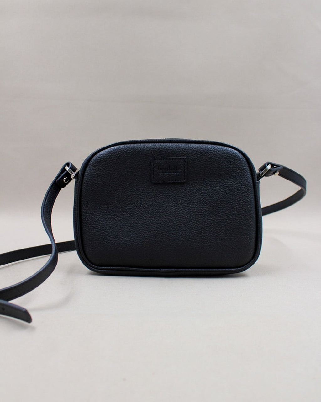 Minaudière cuir grainé noir, bandoulière amovible et logo gravé Berthille