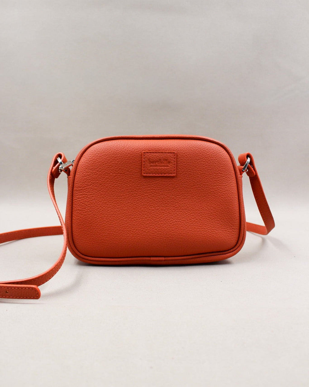 Minaudière cuir grainé orange, bandoulière amovible et logo gravé Berthille
