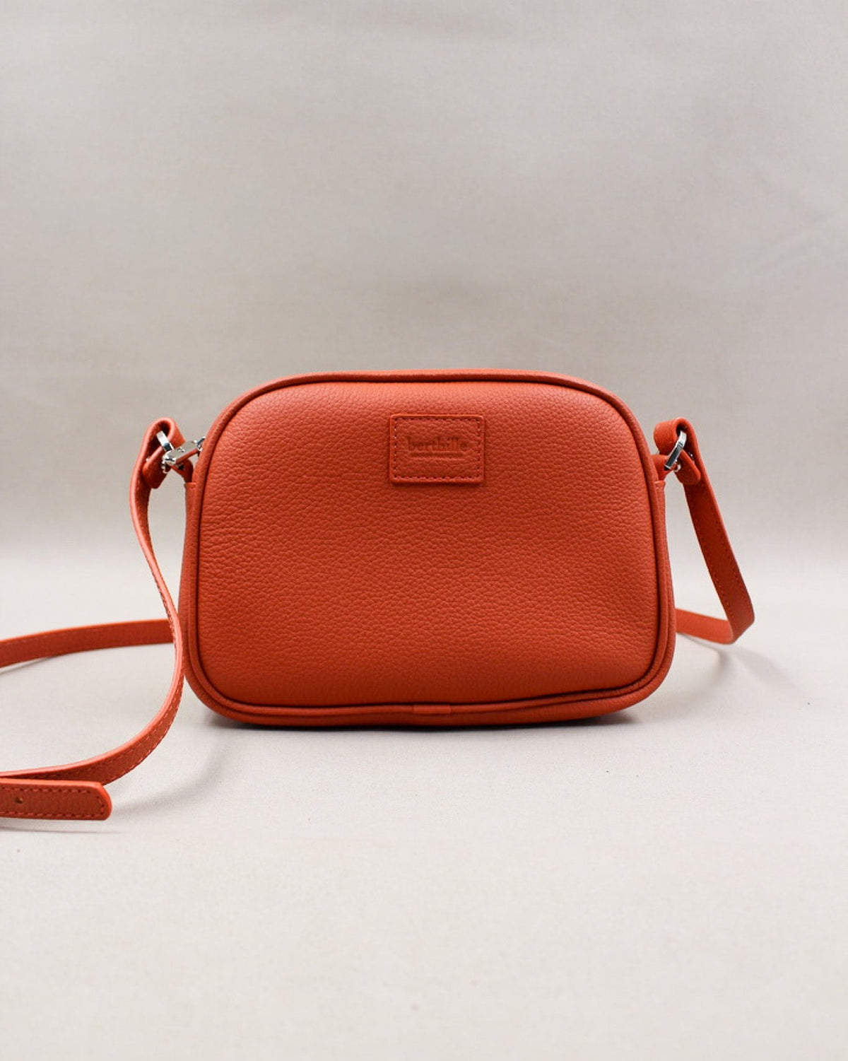 Minaudière cuir grainé orange, bandoulière amovible et logo gravé Berthille