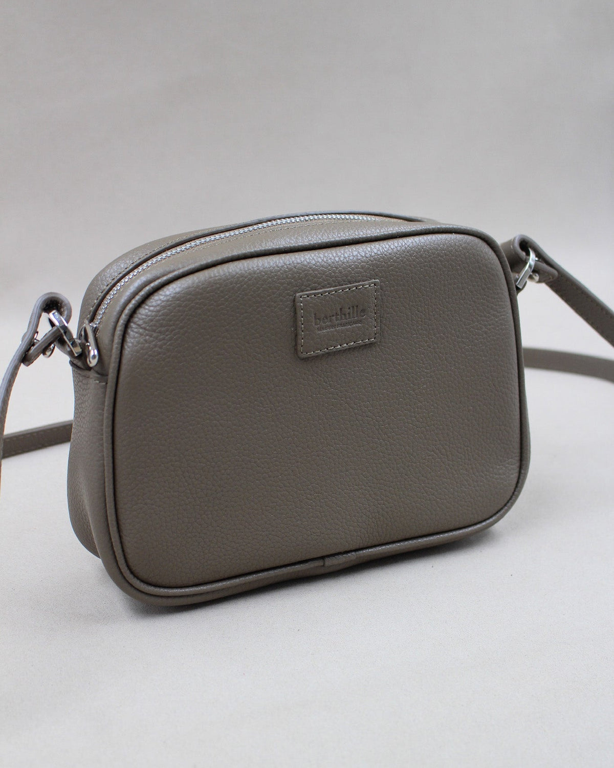 Minaudière cuir grainé taupe, bandoulière amovible et logo gravé Berthille