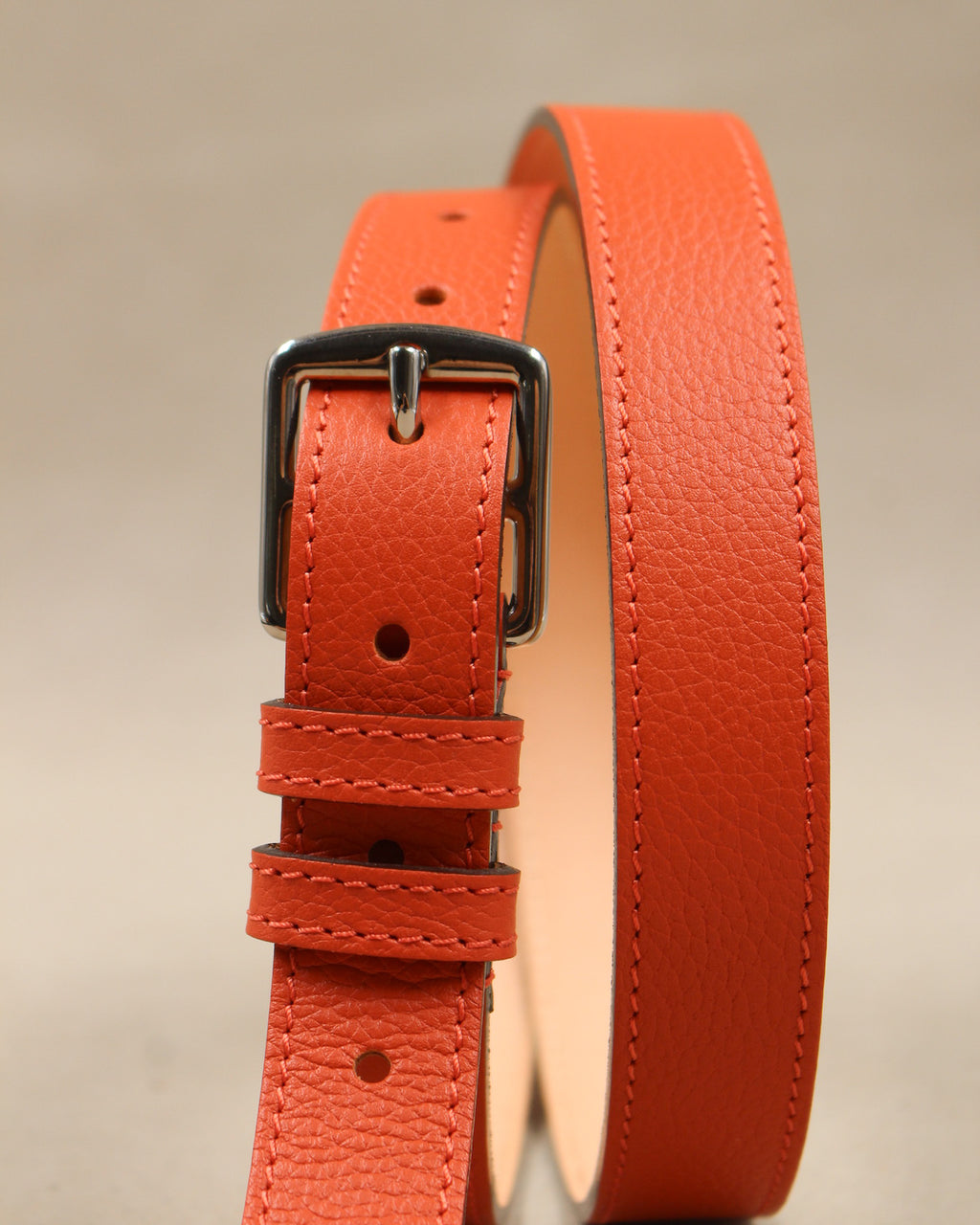 Ceinture étrivière fine Berthille en cuir grainé orange vue de face, boucle argentée, passants et doublure cuir naturel
