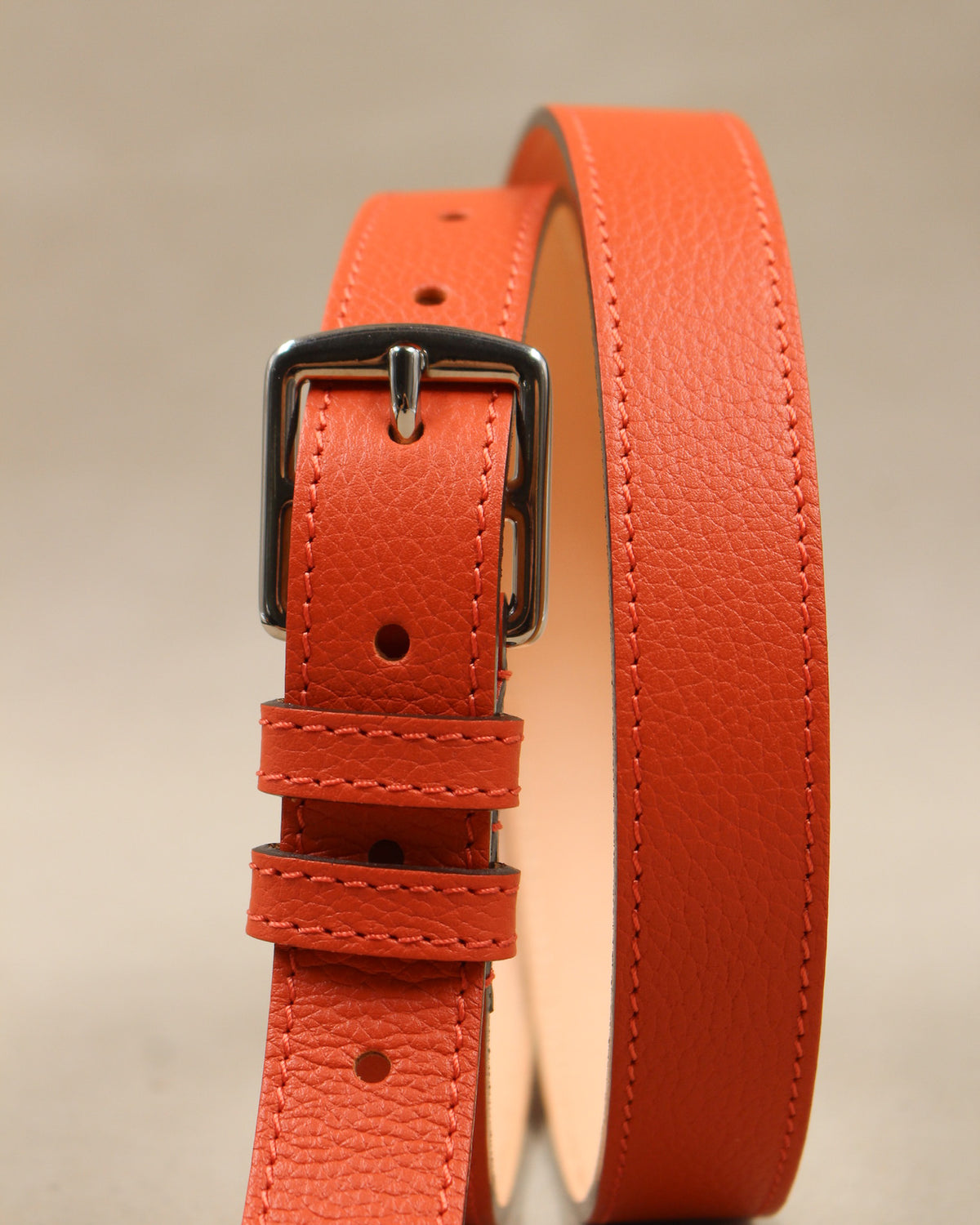 Ceinture étrivière fine Berthille en cuir grainé orange vue de face, boucle argentée, passants et doublure cuir naturel