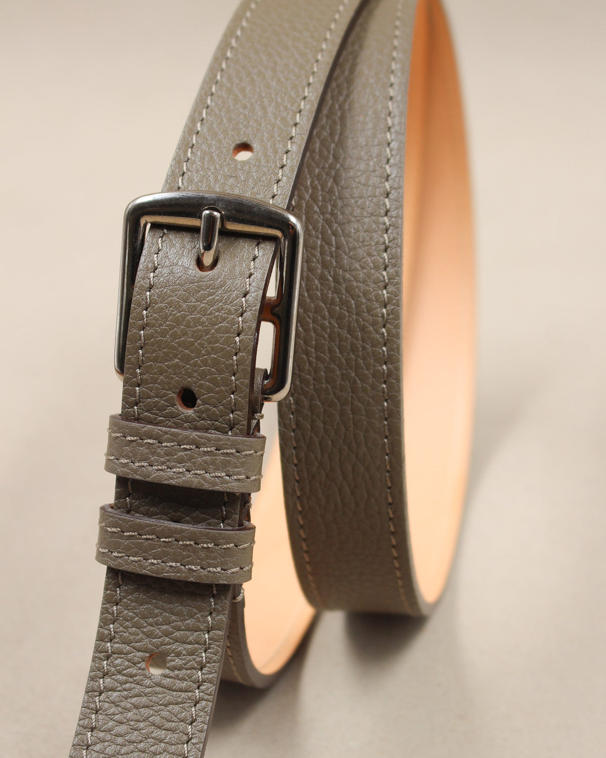 Ceinture étrivière fine Berthille en cuir grainé taupe vue de face, boucle argentée, passants et doublure cuir naturel