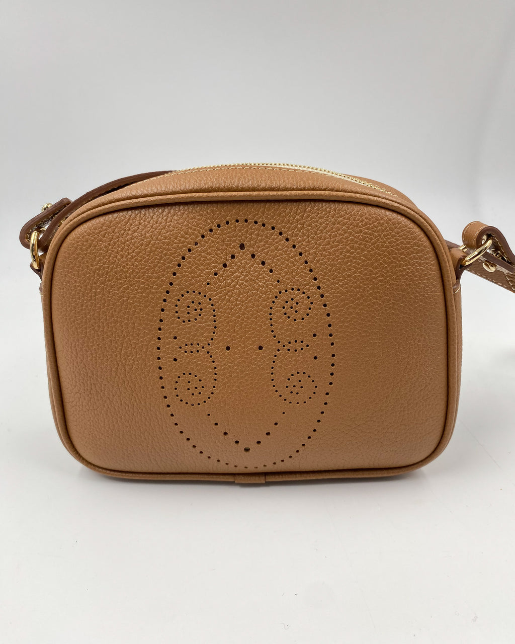 Pochette Trianon en cuir camel vue de face, détail du motif perforé bout fleuri, maroquinerie artisanale Berthille