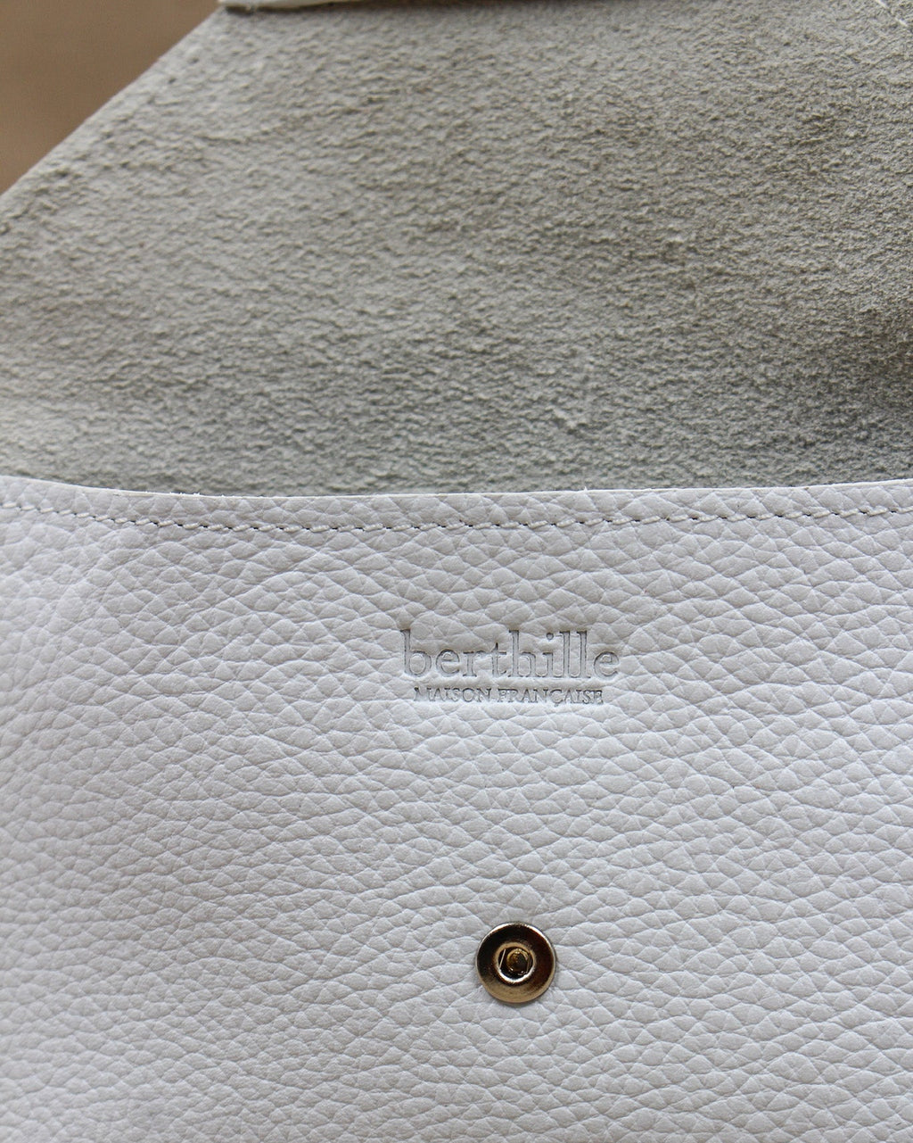 Détail de la pochette Lutecia en cuir pleine fleur Blanc, façonnée à la main à Mazamet
