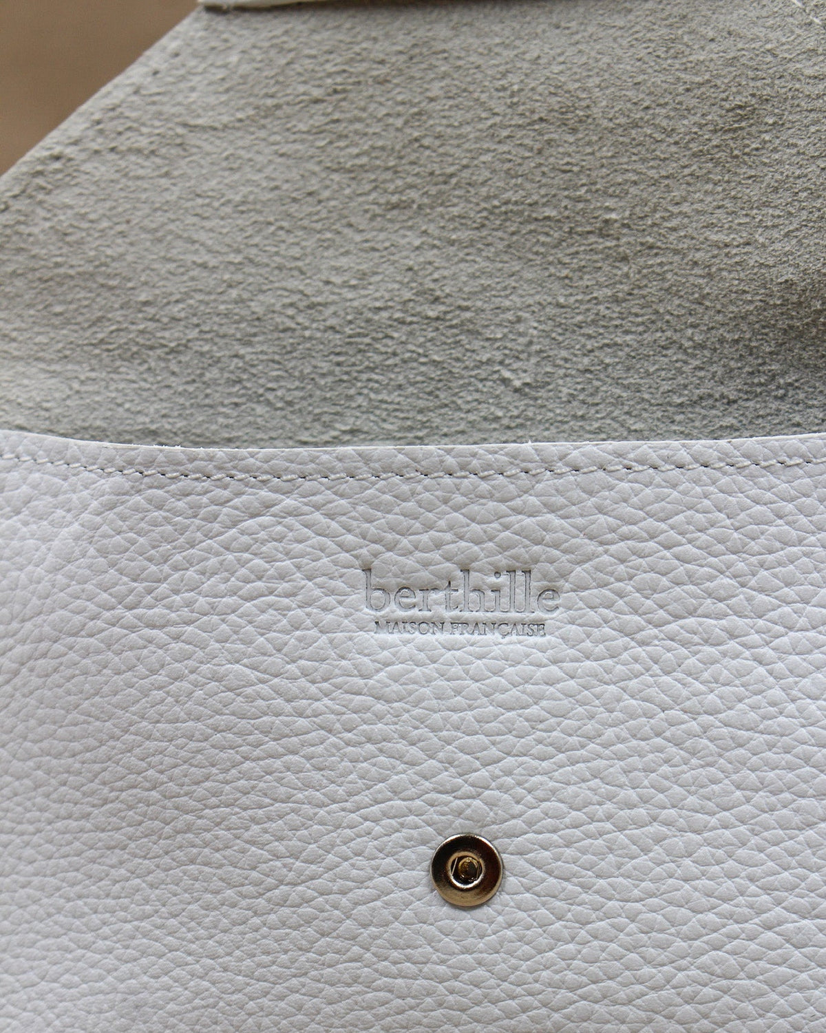 Détail de la pochette Lutecia en cuir pleine fleur Blanc, façonnée à la main à Mazamet