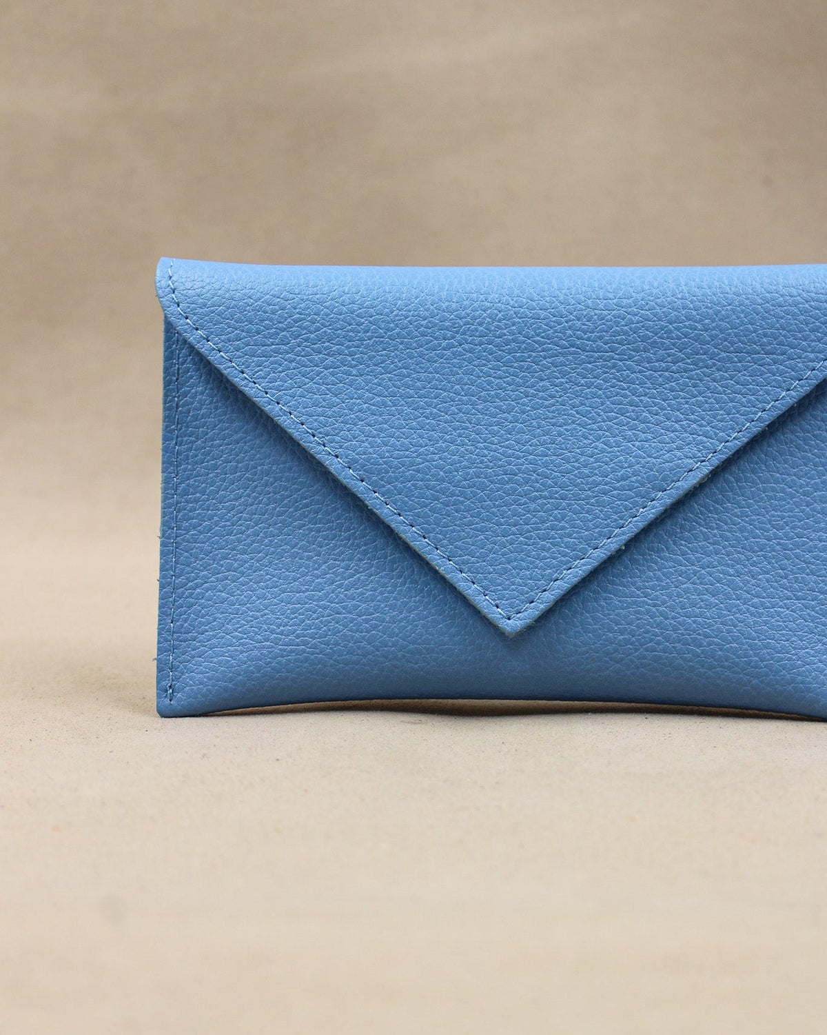 Détail de la pochette Lutecia en cuir pleine fleur Bleu Ciel, façonnée à la main à Mazamet