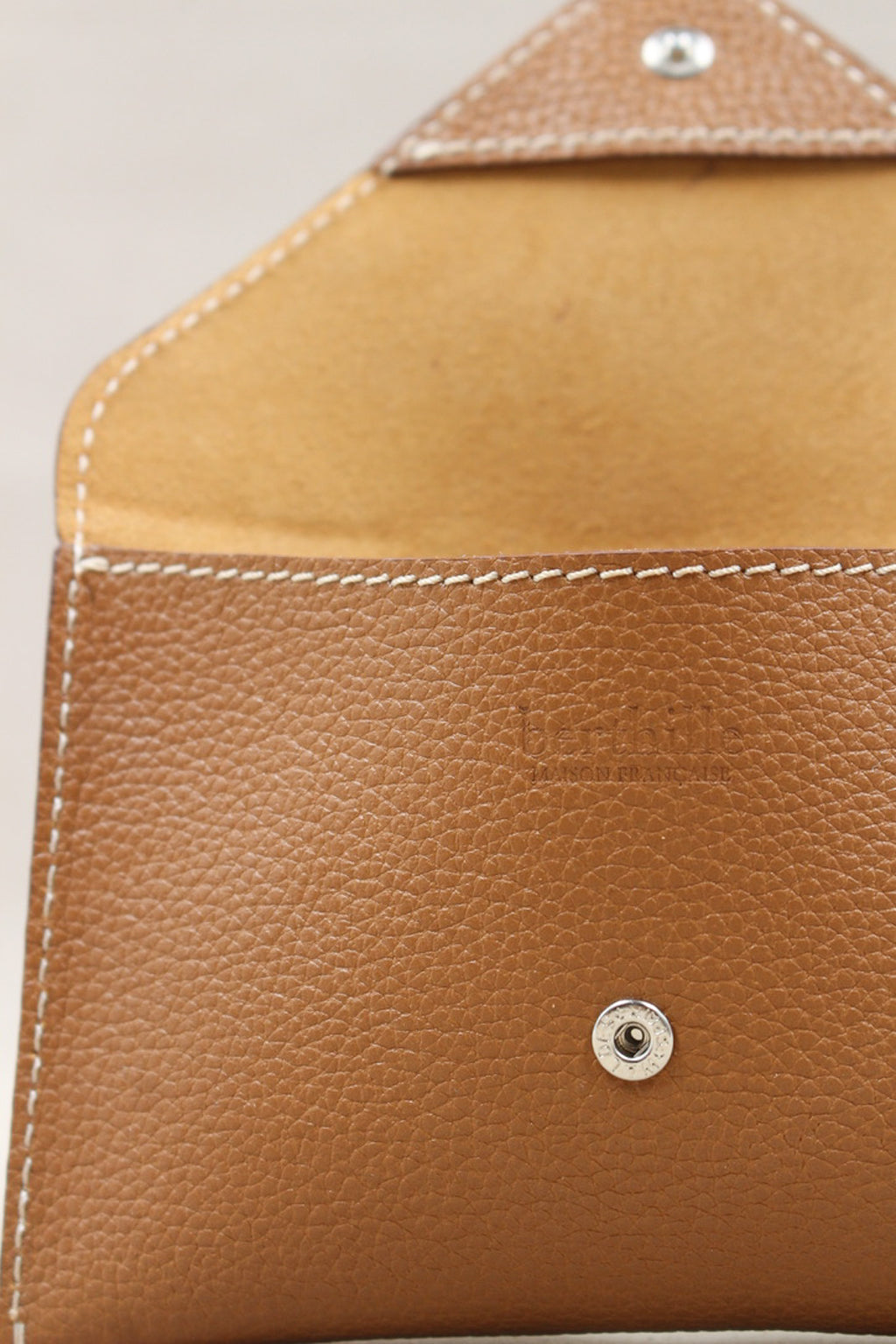 Détail de la pochette Lutecia en cuir pleine fleur Cuero, finitions cousues main, maison Berthille