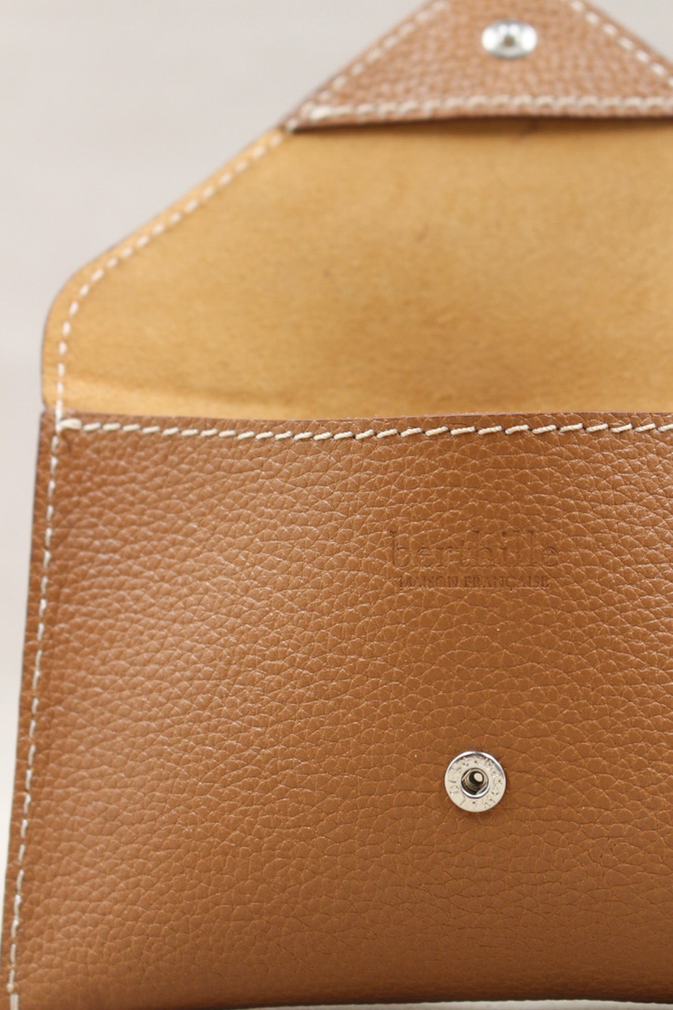 Détail de la pochette Lutecia en cuir pleine fleur Cuero, finitions cousues main, maison Berthille