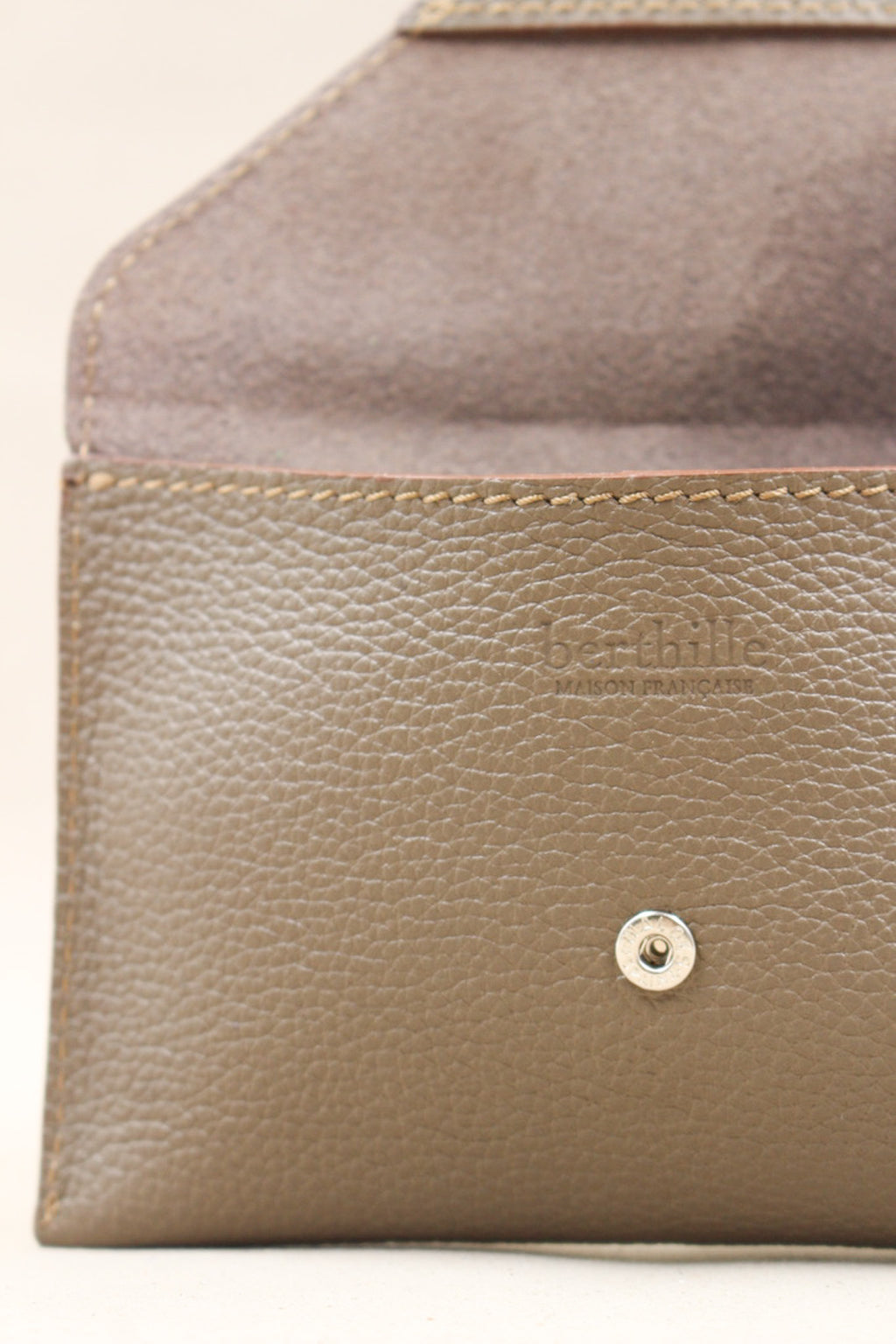 Détail de la pochette Lutecia en cuir pleine fleur Havane, façonnée à la main à Mazamet
