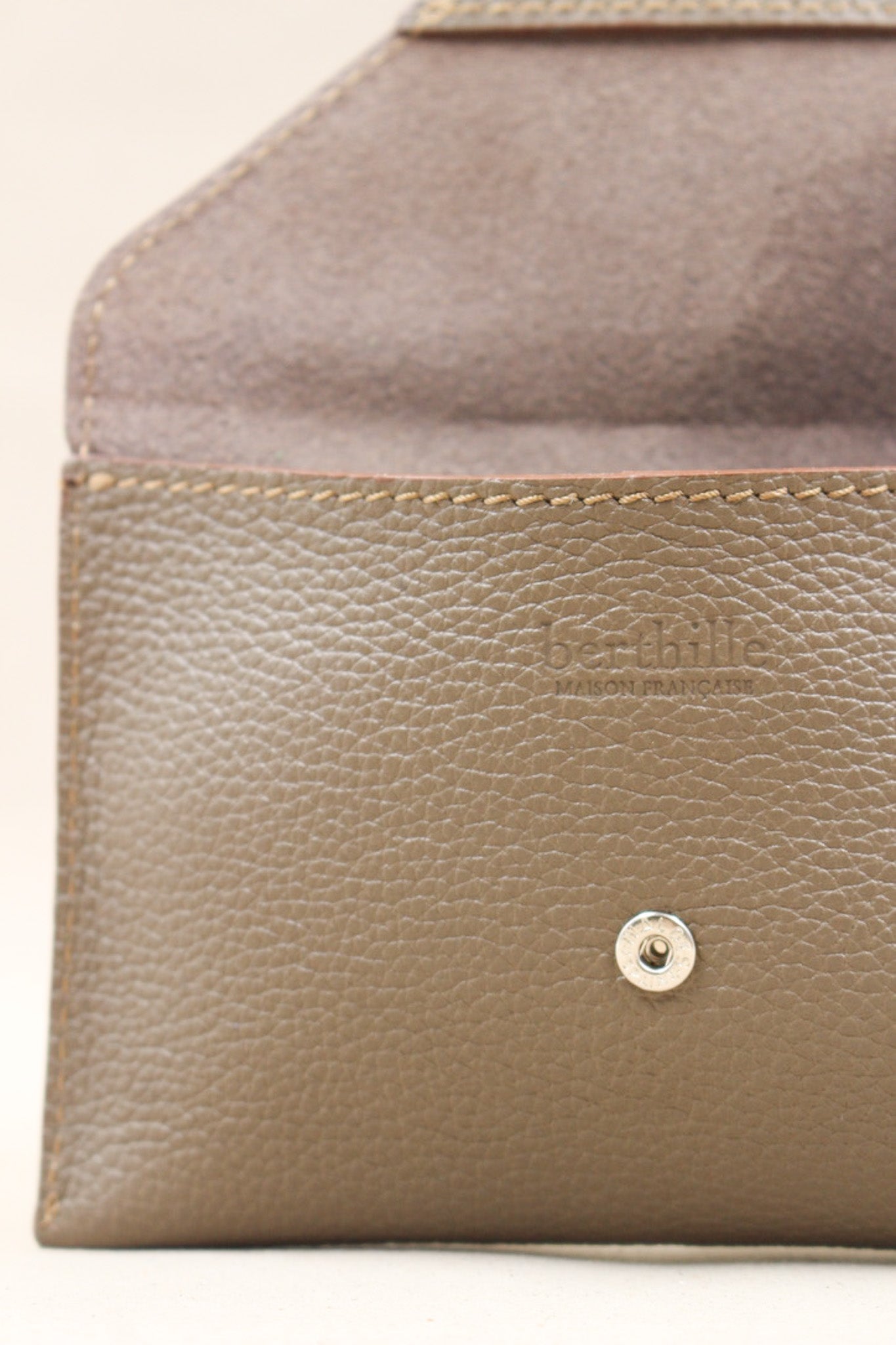 Détail de la pochette Lutecia en cuir pleine fleur Havane, façonnée à la main à Mazamet