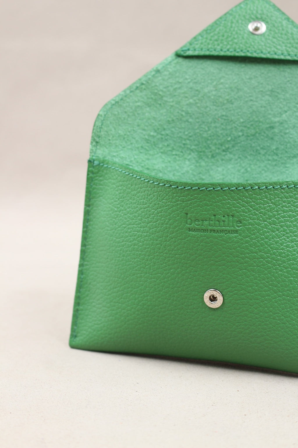 Détail de la pochette Lutecia en cuir pleine fleur Herbe, fermeture pression, façonnée à Mazamet