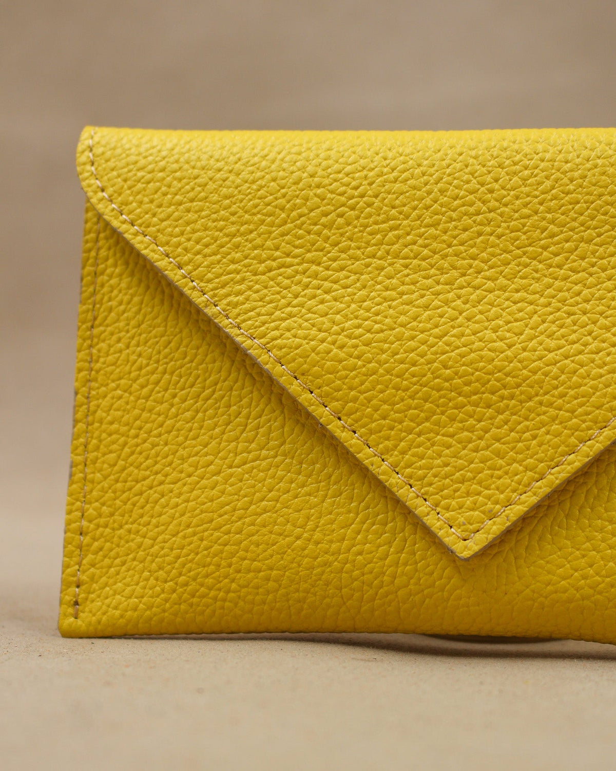 Détail de la pochette Lutecia en cuir pleine fleur Lemon, façonnée à la main à Mazamet