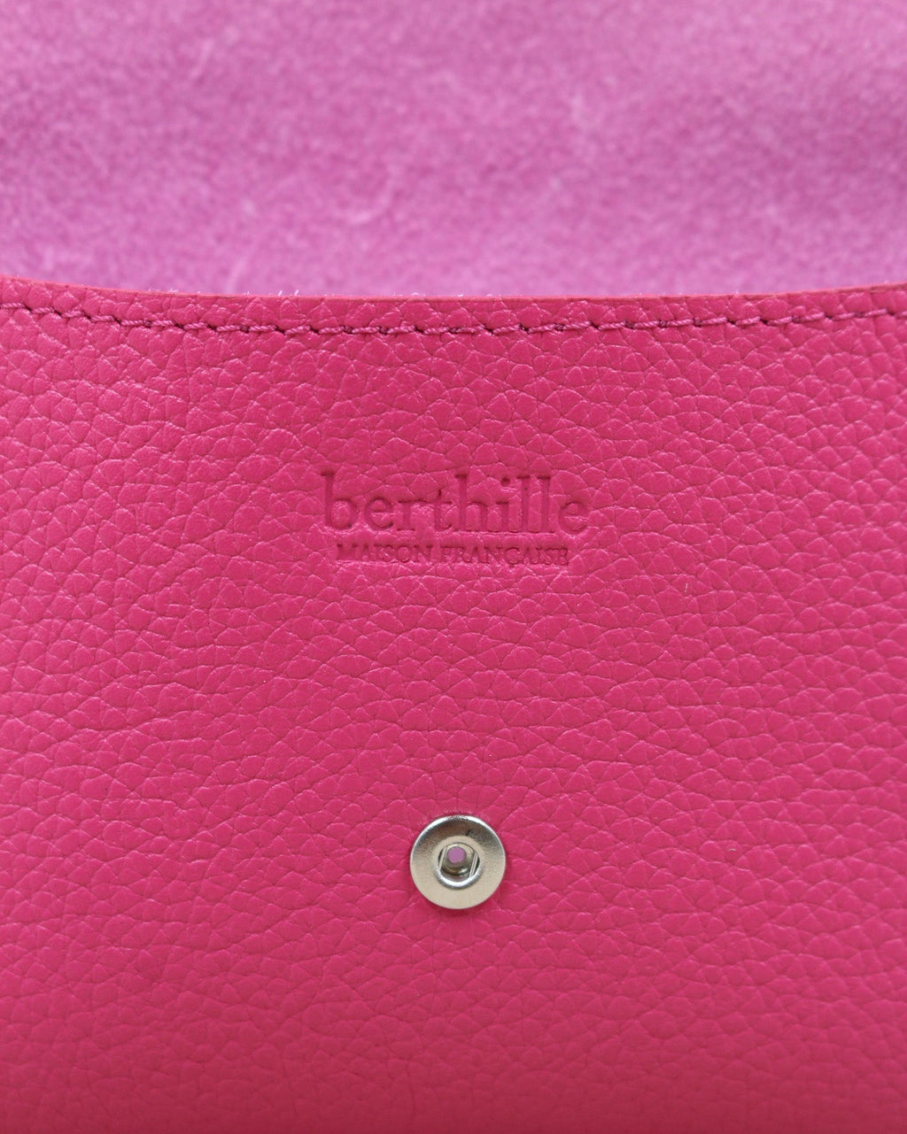 Détail de la pochette Lutecia en cuir pleine fleur Magenta, façonnée à la main à Mazamet