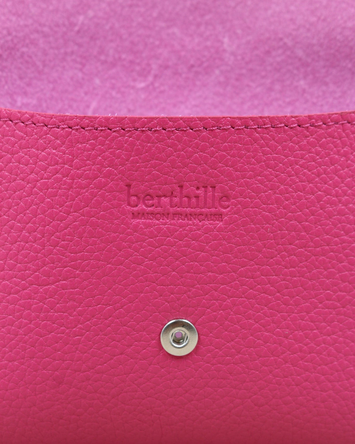 Détail de la pochette Lutecia en cuir pleine fleur Magenta, façonnée à la main à Mazamet