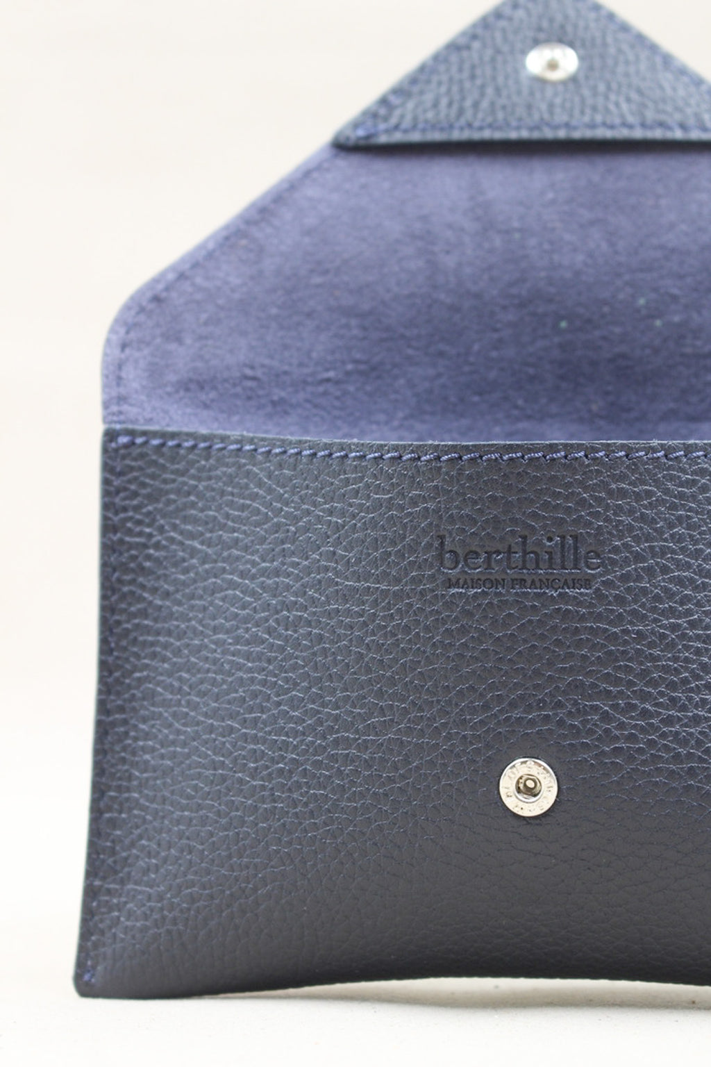 Détail de la pochette Lutecia en cuir pleine fleur Marine, façonnée à la main à Mazamet