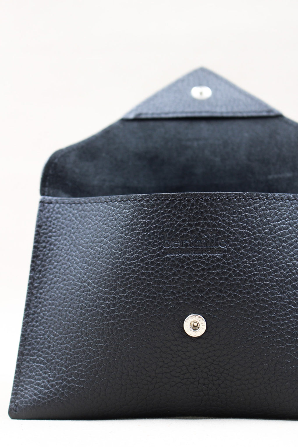 Détail de la pochette Lutecia en cuir pleine fleur Noir, fermeture pression, façonnée à Mazamet