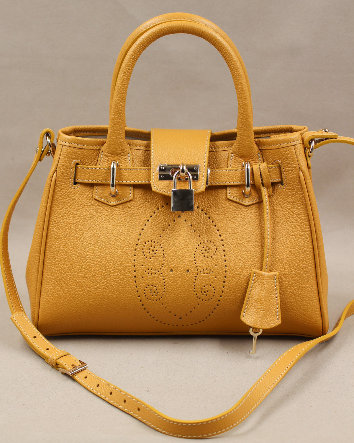 Sac à main mini vendome en cuir jaune moutarde vue de face, motif perforé bout fleuri, deux anses, cadenas argenté et bandoulière amovible, fabriqué en France par Berthille