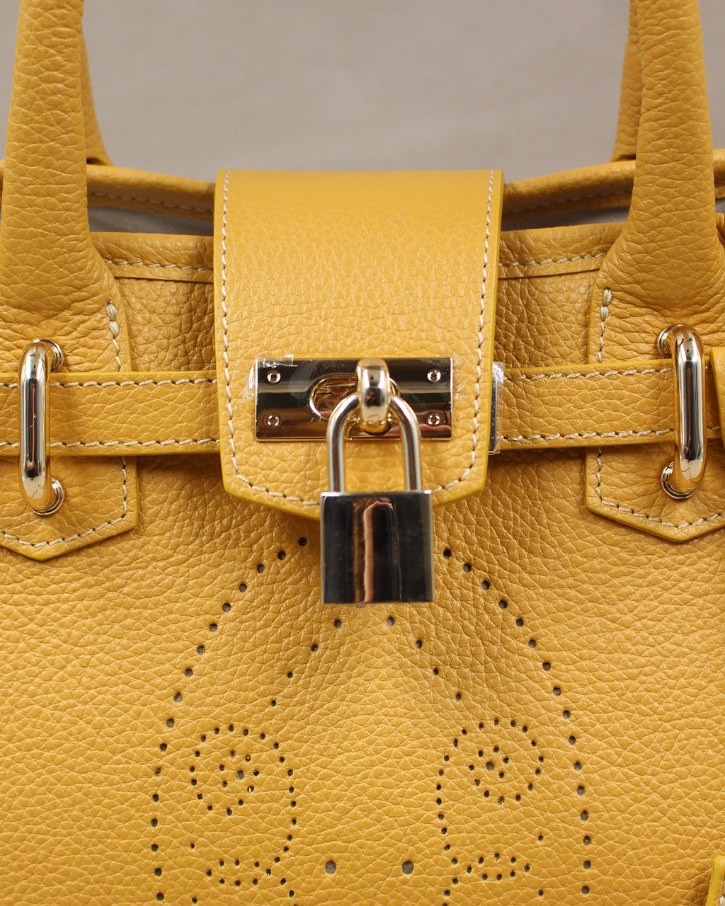 Sac à main Mini Vendôme en cuir jaune moutarde vue de face, motif perforé bout fleuri, deux anses, cadenas argenté et bandoulière amovible, fabriqué en France par Berthille
