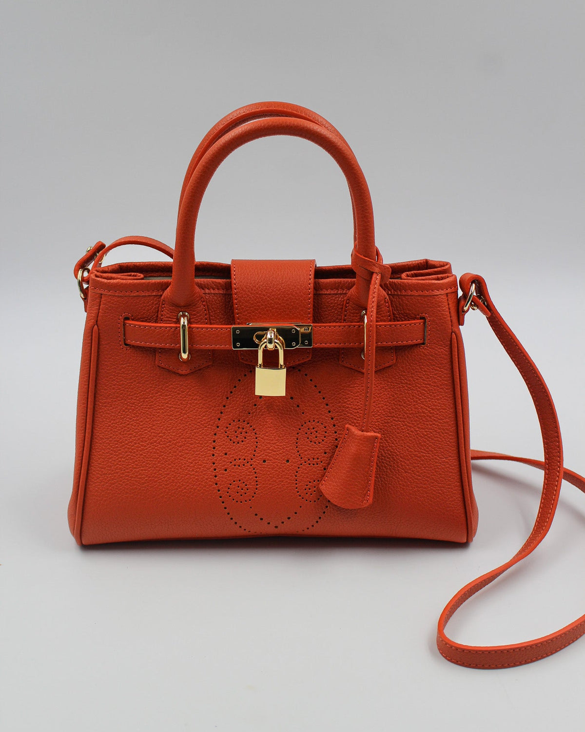 Sac à main Mini Vendôme en cuir orange vue de face, motif perforé bout fleuri, deux anses, cadenas doré, clochette en cuir et bandoulière amovible, fabriqué en France par Berthille