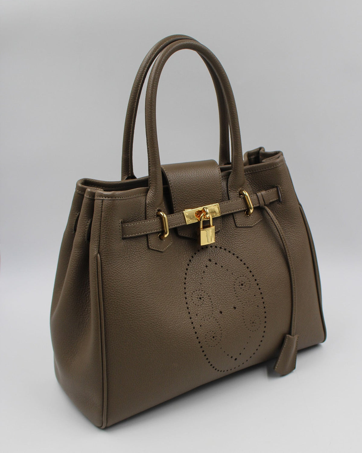 Sac à main Vendôme en cuir gris vue de trois quarts, motif perforé bout fleuri, deux anses, sangle ceinturée, cadenas doré et clochette en cuir, maroquinerie artisanale française