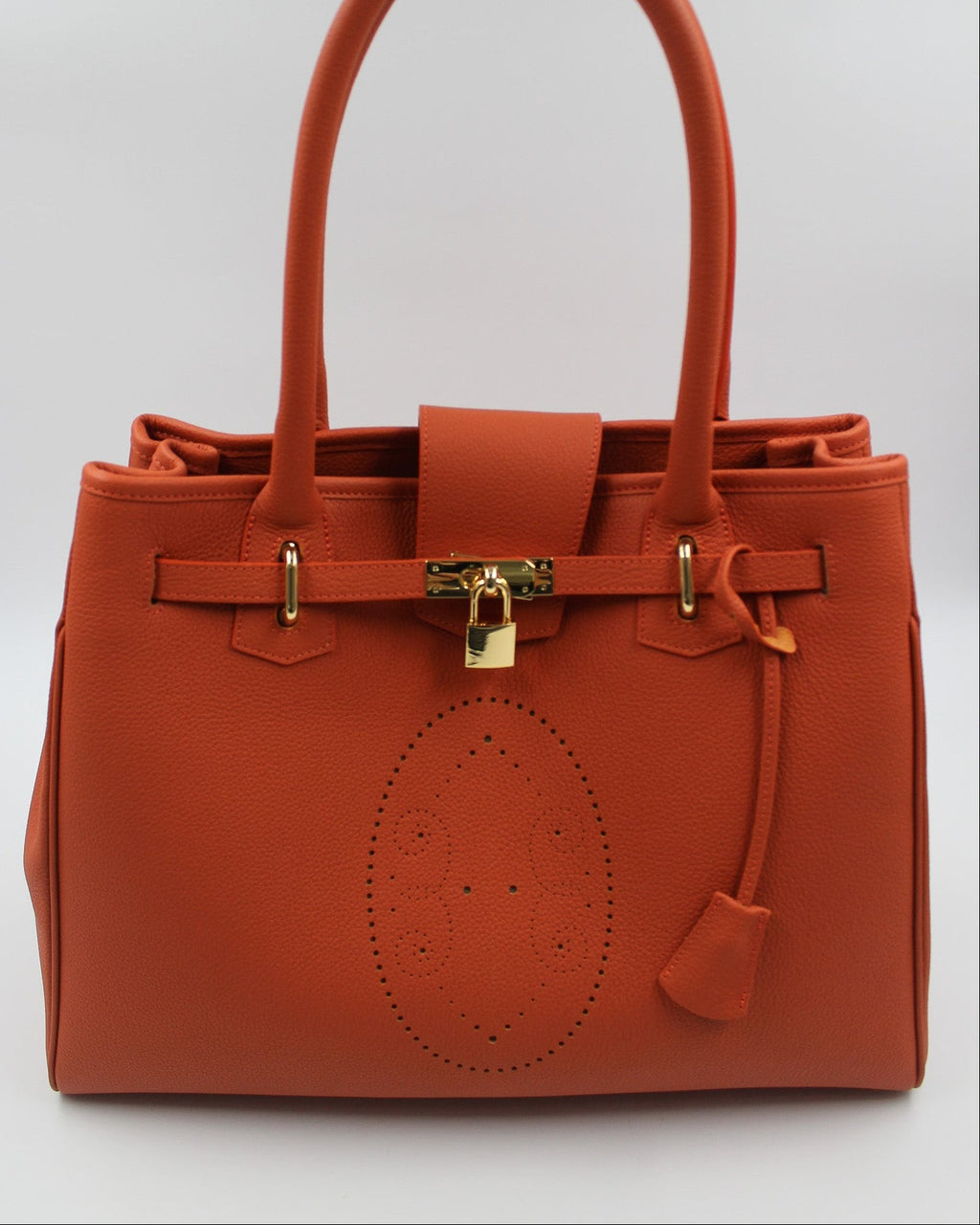 Sac à main Vendôme en cuir orange vue de face, motif perforé bout fleuri, deux anses, sangle ceinturée, cadenas doré et clochette en cuir, fabriqué en France par Berthille
