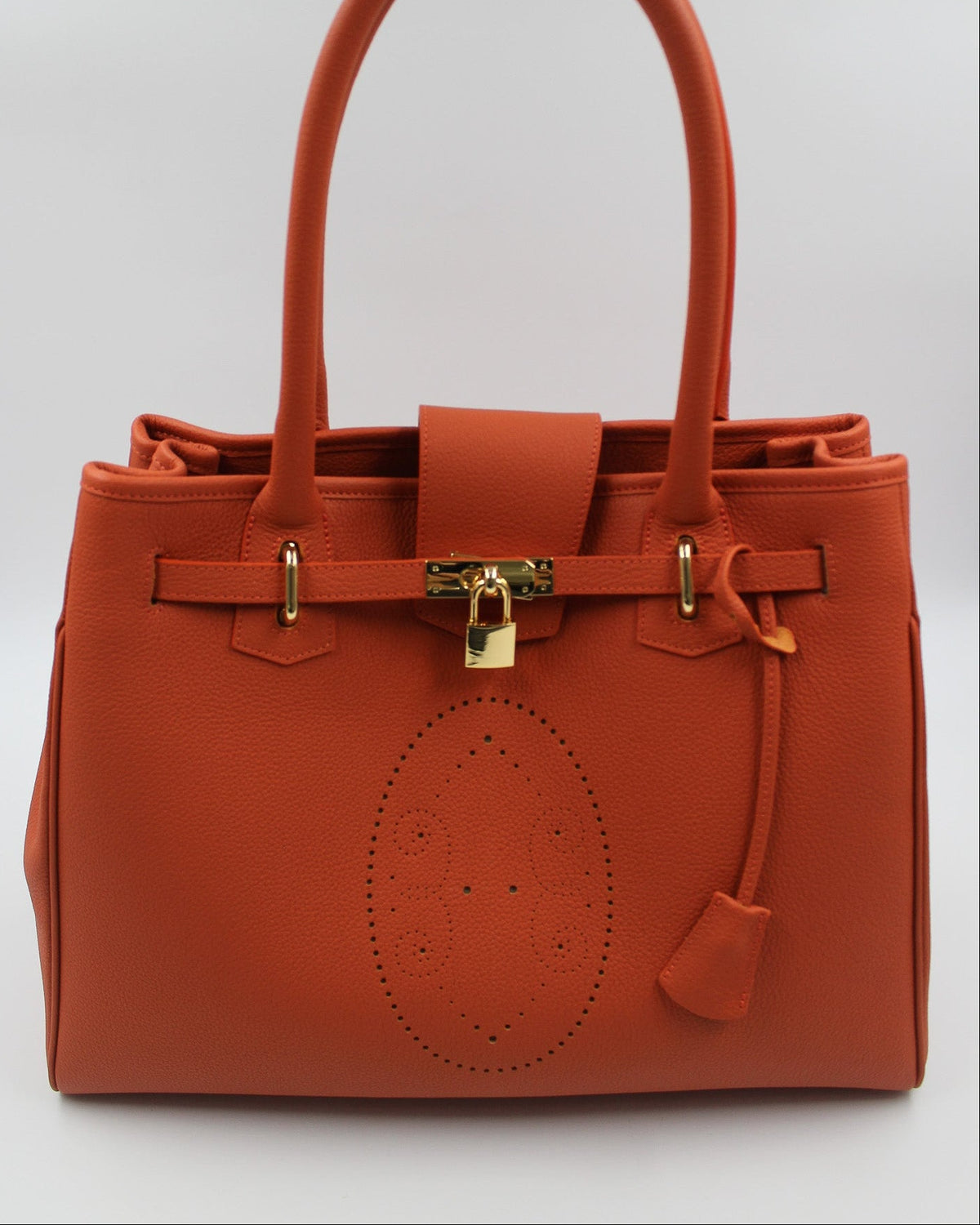Sac à main Vendôme en cuir orange vue de face, motif perforé bout fleuri, deux anses, sangle ceinturée, cadenas doré et clochette en cuir, fabriqué en France par Berthille