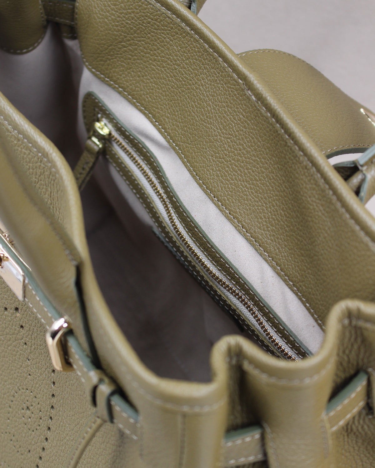 Intérieur du sac à main Vendôme en cuir kaki : doublure gris clair, poche zippée bordée de cuir et grand compartiment principal, fabrication artisanale française
