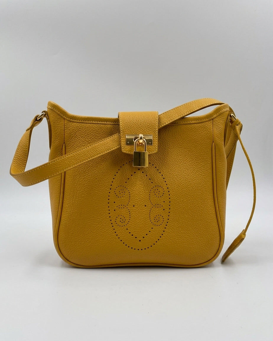 Sac Trianon en cuir jaune moutarde vue de face, motif perforé bout fleuri, rabat et cadenas dorés, fabriqué en France par Berthille